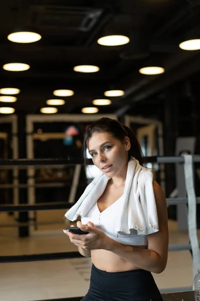 Chica de mensajes de texto mientras toma un descanso en un gimnasio. Lee un mensaje — Foto de Stock