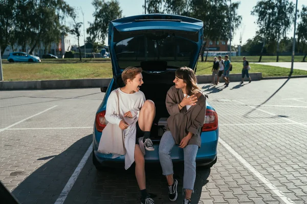 카메라 앞에 포즈를 취하고 있는 두 소녀 가 주차장에 있는 모습. — 스톡 사진