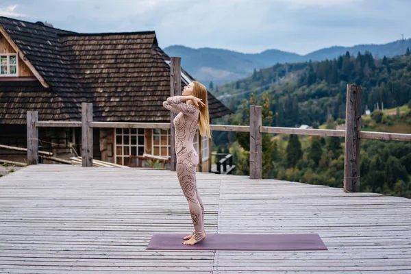 Žena ráno cvičí jógu na terase na čerstvém vzduchu. — Stock fotografie