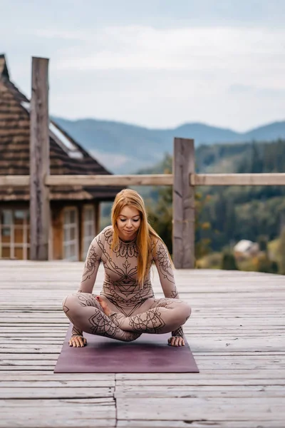 A woman sitting in lotus position at the morning on a fresh air. — 스톡 사진