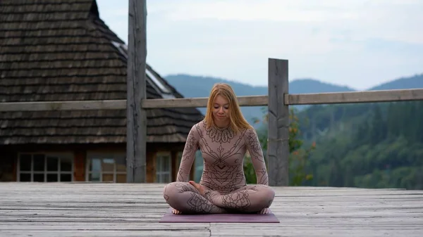 A woman sitting in lotus position at the morning on a fresh air. — Stock Photo, Image