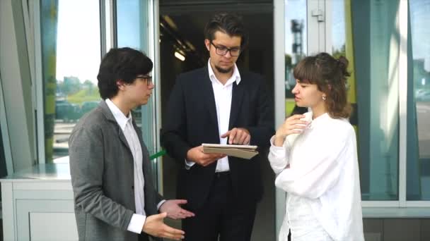 Equipo de negocios dos hombres y una mujer trabajando juntos fuera . — Vídeo de stock