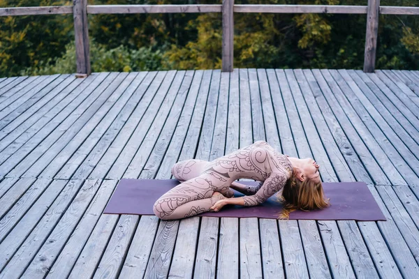 A woman practices yoga at the morning in a terrace on a fresh air. — Stock Photo, Image