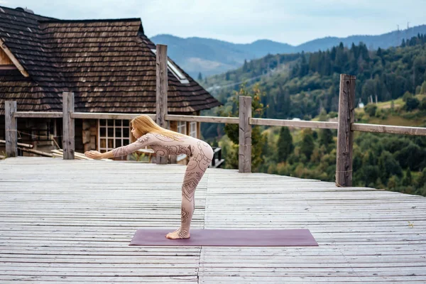 Una donna pratica yoga al mattino in una terrazza all'aria aperta . — Foto Stock