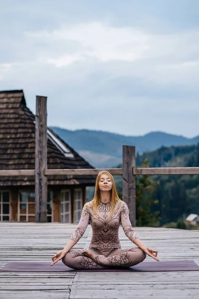 A woman sitting in lotus position at the morning on a fresh air. — 스톡 사진