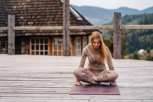 A woman sitting in lotus position at the morning on a fresh air. — 스톡 사진