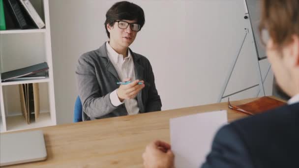 Primer plano de dos personas teniendo una discusión de negocios en un escritorio en una oficina — Vídeos de Stock