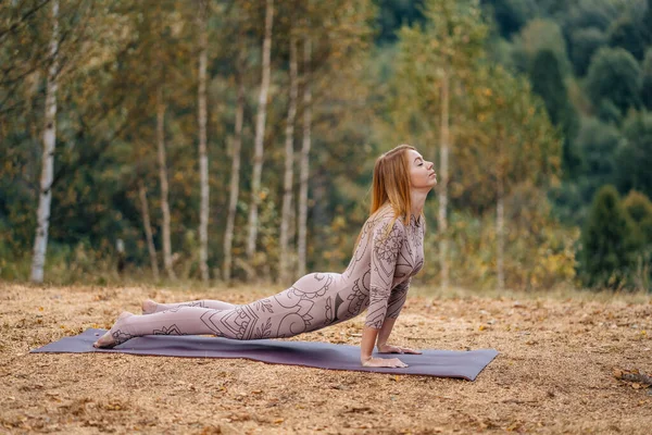 A woman practices yoga at the morning in a park on a fresh air. — 스톡 사진