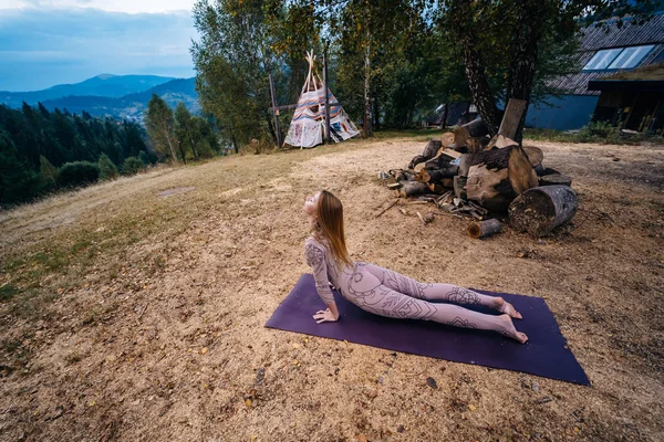 Eine Frau praktiziert morgens Yoga an frischer Luft in einem Park. — Stockfoto