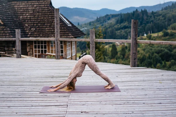 Una donna pratica yoga al mattino in una terrazza all'aria aperta . — Foto Stock