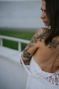 Sıska seksi kadın, beyaz bir elbise içinde arkasını gösteriyor, arkasını kolluyor.