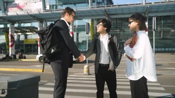 Colleagues meet and shake hands in urban environment background. — Stock Video