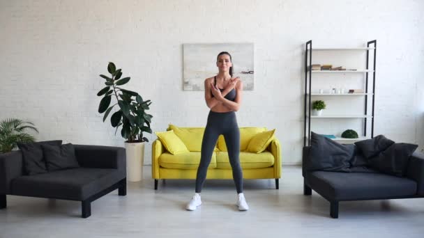 Hermosa mujer joven haciendo ejercicios abdominales en la habitación — Vídeo de stock