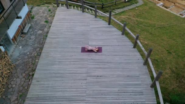 Bir kadın sabah terasta temiz havada yoga yapıyor.. — Stok video