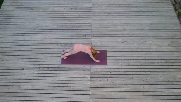 Una mujer practica yoga por la mañana en una terraza al aire libre . — Vídeo de stock