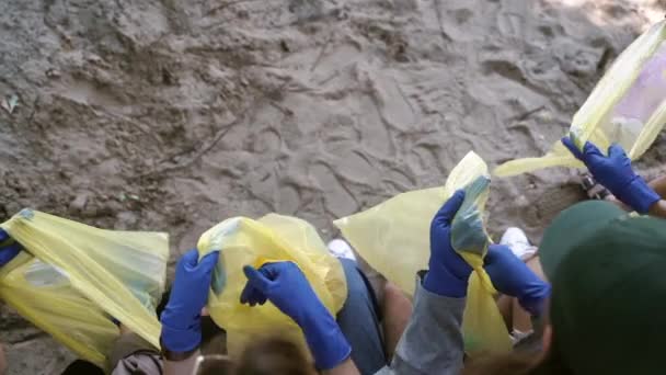 Grupo de activistas amigos clasifican la basura en bolsas. Conservación ambiental . — Vídeo de stock