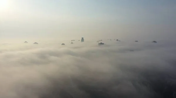 Légi felvétel a városra a ködben. Felhőkarcolók a köd felett — Stock Fotó