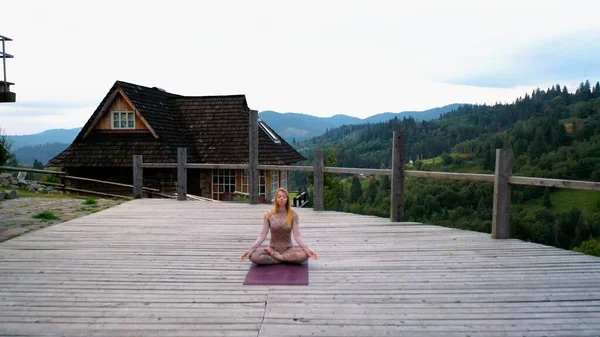 Una donna pratica yoga al mattino in una terrazza all'aria aperta . — Foto Stock