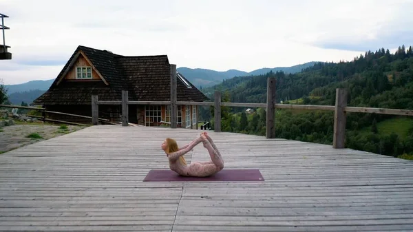 Una donna pratica yoga al mattino in una terrazza all'aria aperta . — Foto Stock