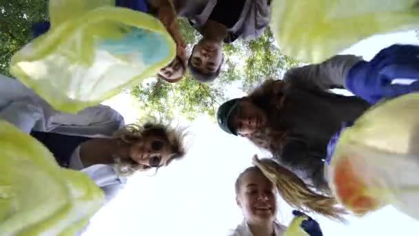 Eine Gruppe befreundeter Aktivisten wirft jede Menge Müll in eine Tüte. Bottom-up-Schießen — Stockvideo