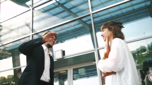 Smartly dressed young man and woman giving high five in a business meeting outdoor — Stock Video