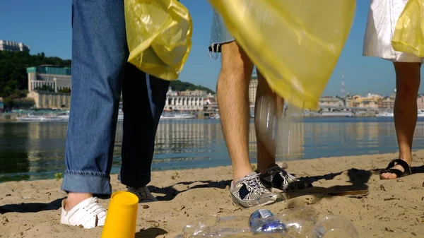 Ομάδα ακτιβιστών φίλοι μαζεύουν πλαστικά απόβλητα στην παραλία. Προστασία του περιβάλλοντος. — Φωτογραφία Αρχείου