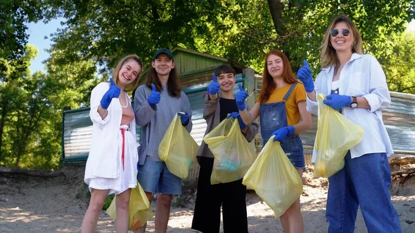 Группа друзей активистов собирает пластиковые отходы на пляже. Охрана окружающей среды . — стоковое фото