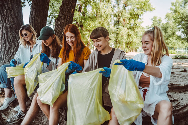Группа друзей активистов собирает пластиковые отходы в парке. Охрана окружающей среды
.