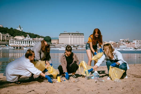 Группа друзей активистов собирает пластиковые отходы на пляже. Охрана окружающей среды . — стоковое фото