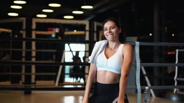 Sorrindo ajuste menina segurando toalha e descansar no ginásio . — Vídeo de Stock