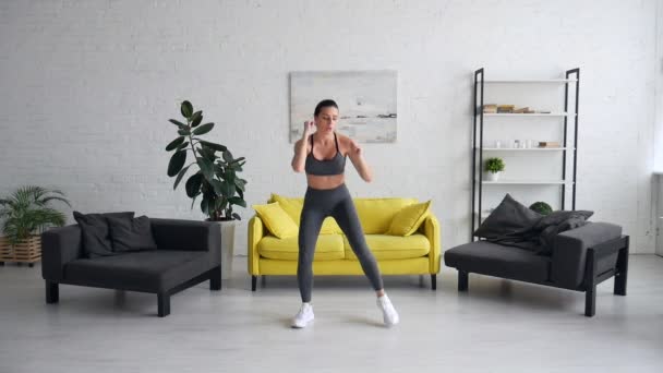 Piękna młoda kobieta robi ćwiczenia brzucha w pokoju — Wideo stockowe