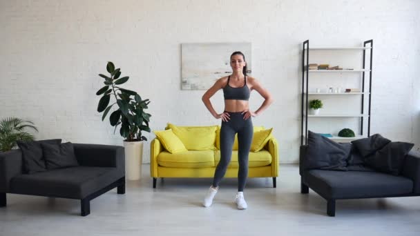 Hermosa mujer joven haciendo ejercicios abdominales en la habitación — Vídeos de Stock