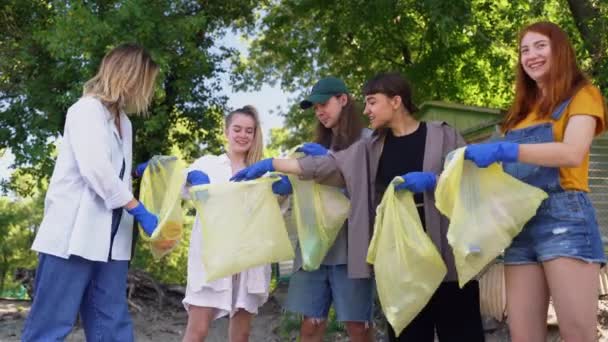 Grupo de activistas amigos recogiendo residuos plásticos en la playa. Conservación ambiental . — Vídeo de stock