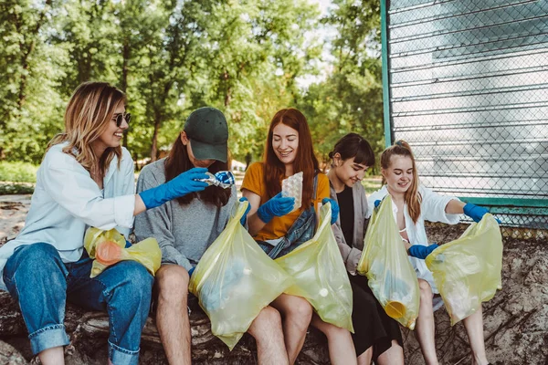 Группа друзей активистов собирает пластиковые отходы в парке. Охрана окружающей среды . — стоковое фото