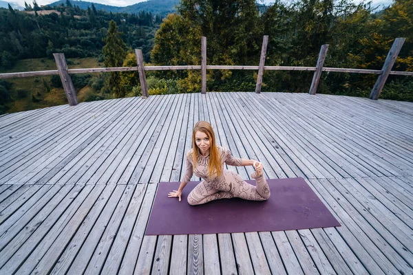 Žena ráno cvičí jógu na terase na čerstvém vzduchu. — Stock fotografie