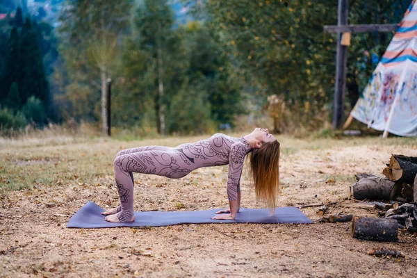 A woman practices yoga at the morning in a park on a fresh air. — 스톡 사진