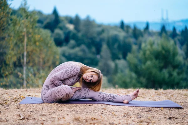 Žena ráno cvičí jógu v parku na čerstvém vzduchu. — Stock fotografie