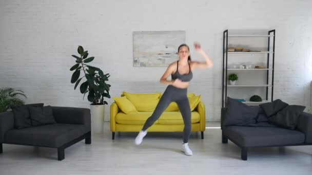 Hermosa mujer joven haciendo ejercicios abdominales en la habitación — Vídeos de Stock