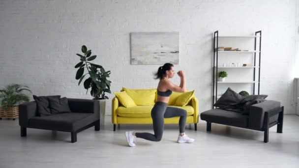 Hermosa mujer joven haciendo ejercicios abdominales en la habitación — Vídeos de Stock