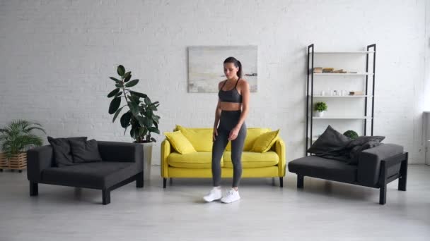 Красива молода жінка робить вправи на животі в кімнаті — стокове відео