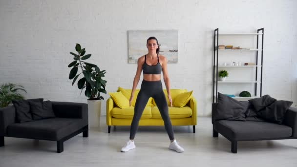 Schöne junge Frau macht Bauchmuskelübungen im Zimmer — Stockvideo