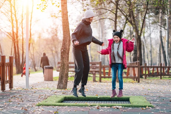 Mutter und Tochter springen gemeinsam auf Trampolin im Herbstpark — Stockfoto