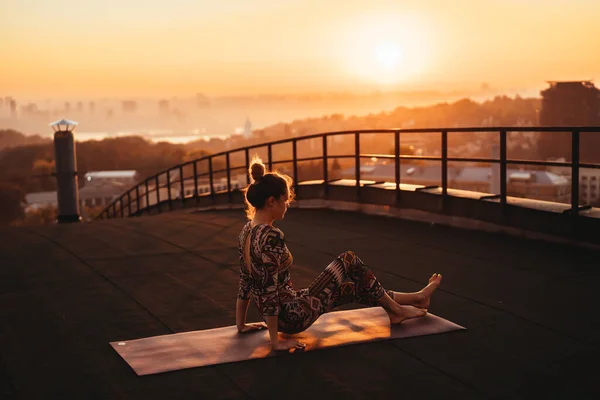 Mujer haciendo yoga en el techo de un rascacielos en la gran ciudad . —  Fotos de Stock