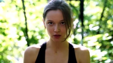 Parkta kameraya gülümseyen güzel genç kız