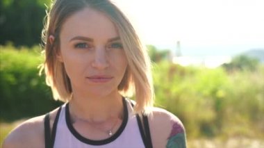 Parkta kameraya gülümseyen güzel genç kız