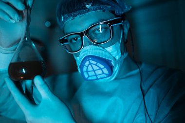 Genç erkek araştırmacı bilimsel deney yapıyor..