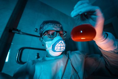 Genç erkek araştırmacı bilimsel deney yapıyor..