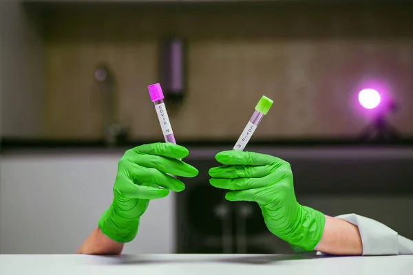 Руки в резиновых перчатках держит две пробирки с коронавирусом — стоковое фото