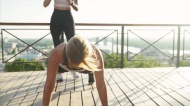 Büyük şehrin arka planında spor kızları var. Atletik genç kadınlar sabah egzersizleri yapıyor..