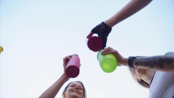 Sağlıklı yaşam tarzı kavramı. Spor kızları. Kızlar şişeleri tokuşturur — Stok video